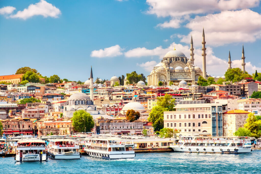 Touristic Sightseeing Ships In Golden Horn Bay Of Istanbul And View On Suleymaniye Mosque With Sultanahmet District Against Blue Sky And Clouds. Istanbul, Turkey During Sunny Summer Day.